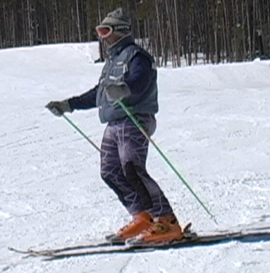 Skier standing tall with some flexing at ankles and knees.
