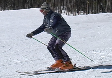 A skier very bent at knees and waist so they are centre balanced but low and hunched.